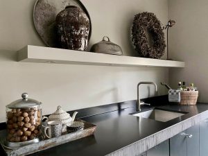 Landelijke zwarte keuken zonder bovenkastjes dienblad met theekan krans en zilveren cloche