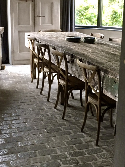 Lange eettafel met houten stoelen RAW stones vloer