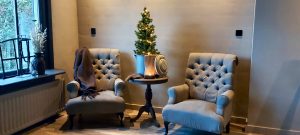 landelijke fauteuil kerstboompje wijntafel oude poer zwarte kozijnen plaid