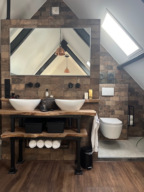 Badkamer landelijk chique houten plank waskommen bruine tegels hanglamp koper