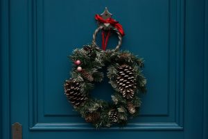 Eenvoudige kerstkrans aan donkerblauwe deur