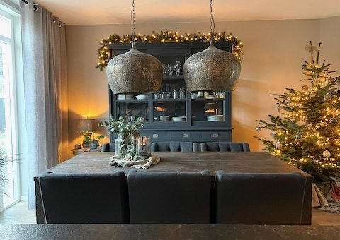 Grote lampen boven landelijke eettafel kerst versiering woonkamer