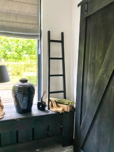 Houten binnen schuifdeur landelijk radiator ombouw zwart decoratieladder hout zwarte kruik vensterbank