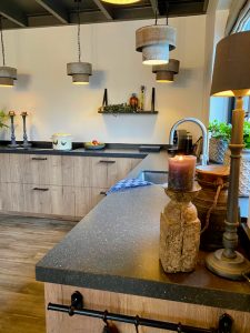 Open houten keuken zonder boven kastjes meerdere hanglampen landelijk theedoek geblokt keuken decoratie aanrecht landelijk