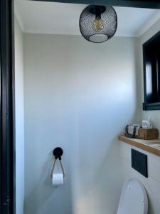 Draadlamp zwart plafond toilet wc papier aan touw houten plank wc zwart raamkozijn steenmal met toilet verfrissen