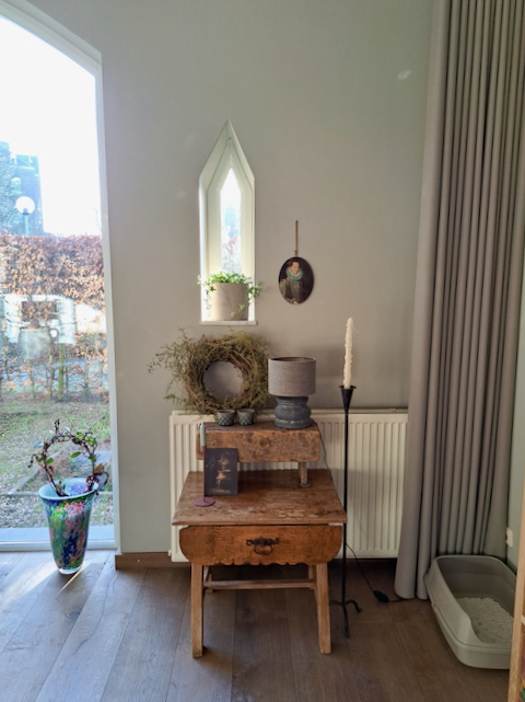 Oud houten tafeltje krans met Asparagus takken balusterlamp Brynx hoge vloerkandelaar kerkraam driehoek
