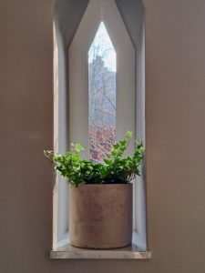 Klimop in bloempot in vensterbank driehoek raam