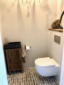 Waaltjesvloer landelijk toilet houten plank achter de wc houten fonteintje