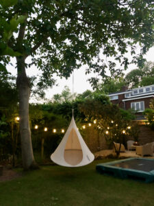 Cocoon hangstoel tuinverlichting trampoline IKEA tuinstoelen op terras wit grind