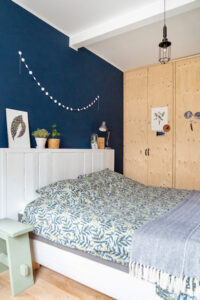 Kasten wand onbewerkt hout slaapkamer blauwe muur achter het bed plank hoofdbord bed