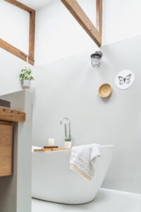 Witte moderne badkamer houten balken losstaand ligbad muurcirkel zwart wit