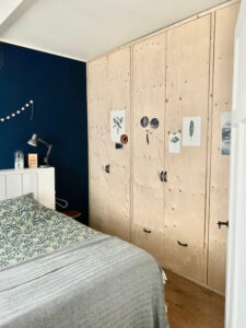 Kastenwand blank hout blauwe muur slaapkamer mintgroen krukje