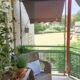 Balkon landelijk ingericht met rotan tuinstoel en taupe zonwering lavendel in pot op tuintafeltje