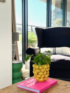 Gele vaas met citroenen oorfauteuil roze boek HK Living gestreepte lampenvoet zwart wit