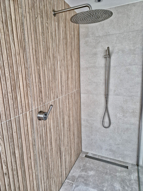 Badkamer tegels verticale lijnen regendouche grijze vloertegels