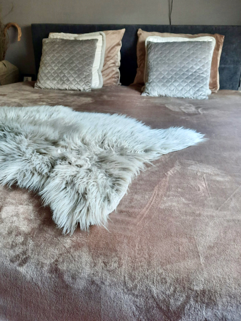 Schapenvacht bed sierkussen velours met ruitpatroon taupe deken landelijke slaapkamer